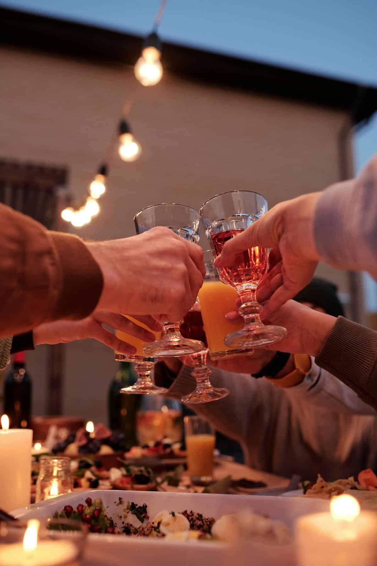Brindis con copas de cristal en cena de catering con farolillos