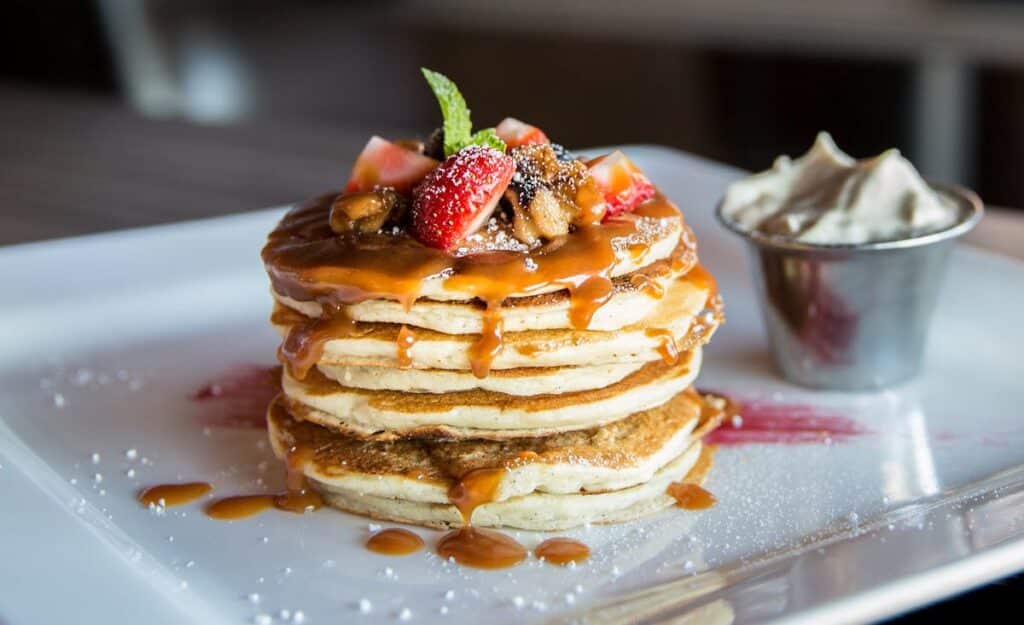 Torre de tortitas con caramelo, fresas y nata para catering de desayuno