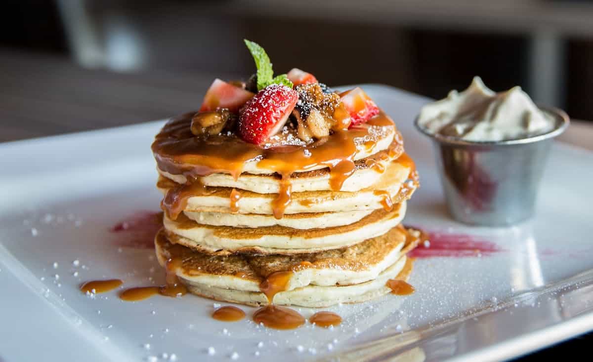 Torre de tortitas con caramelo, fresas y nata para catering de desayuno